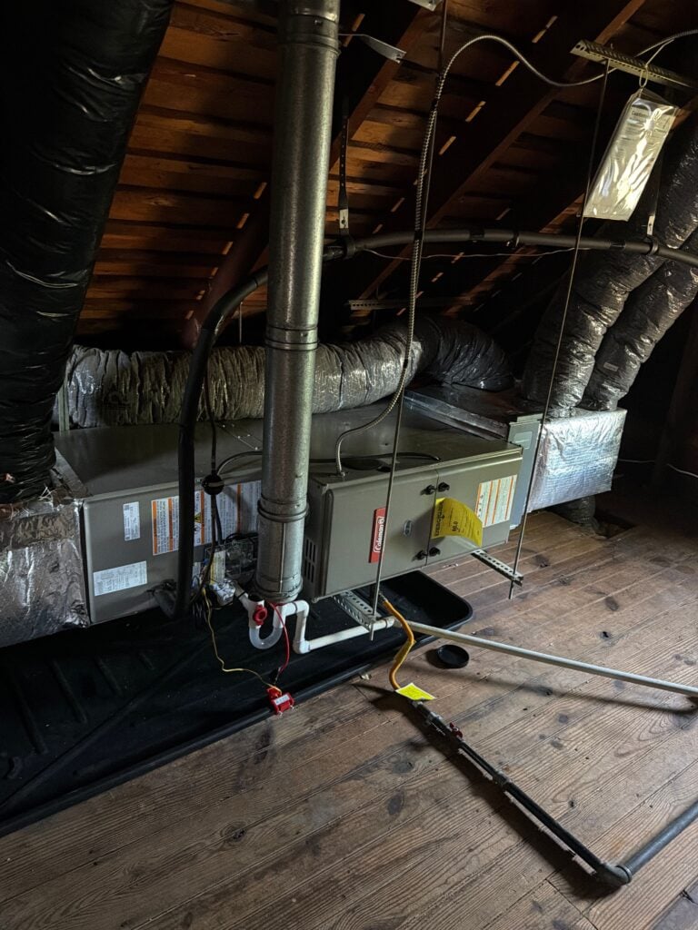 New Coleman gas furnace installed in an attic by Spartan Home Pros