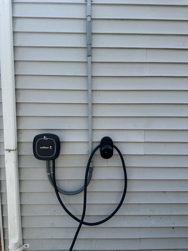 Outdoor Level 2 EV charger mounted on an exterior wall by Spartan Home Pros