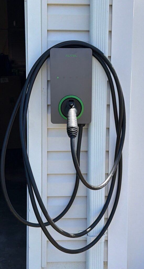 Exterior EV charger installed on a garage wall by Spartan Home Pros