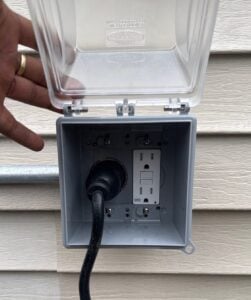 Outdoor generator hookup with a weatherproof cover installed by Spartan Home Pros