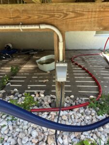 Weatherproof outlet installed under a deck for pool equipment — Spartan Home Pros, serving Old Bridge, NJ