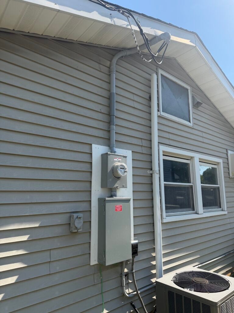Outdoor AC unit and its service switch on the side of a home in Old Bridge, NJ