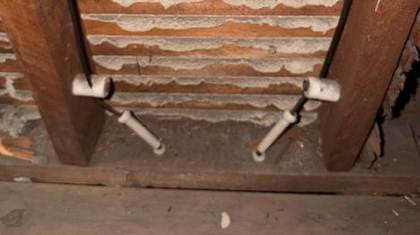 Old knob and tube wiring running through porcelain tubes in the framing of a New Jersey home