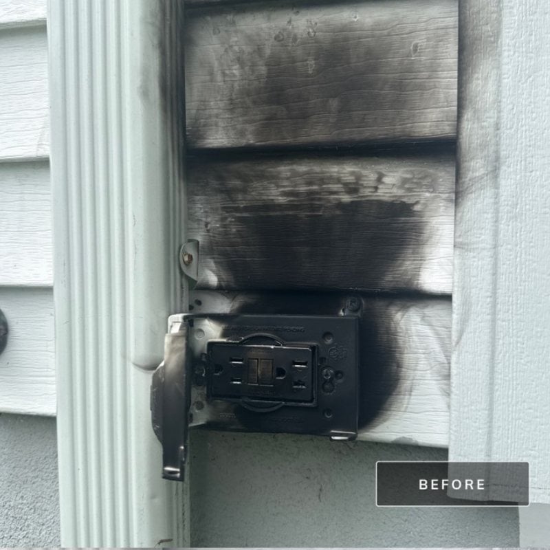 Burned outdoor outlet and scorched siding on a New Jersey home before repair