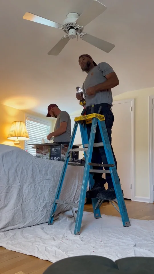 Spartan Home Pros electrician installing a ceiling fan in a New Jersey bedroom