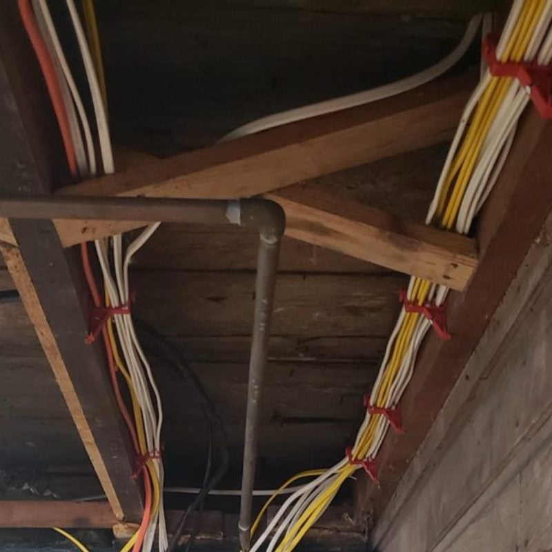 New wiring run neatly through basement joists by Spartan Home Pros